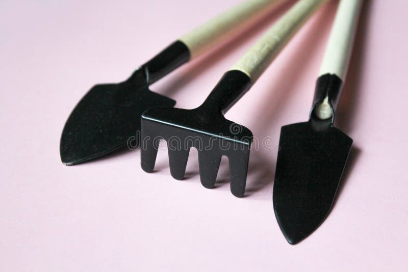 set of three garden tools on pink background