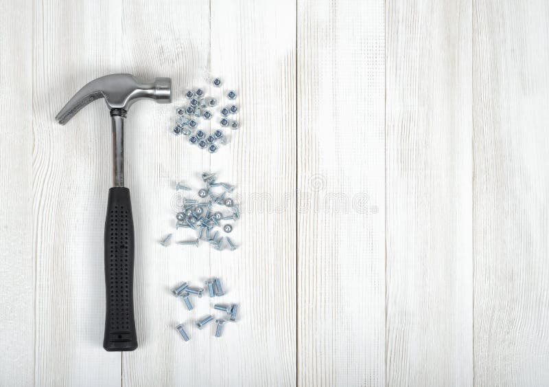 Pile of Rivets, Nails and a Hammer on White Background Stock Photo