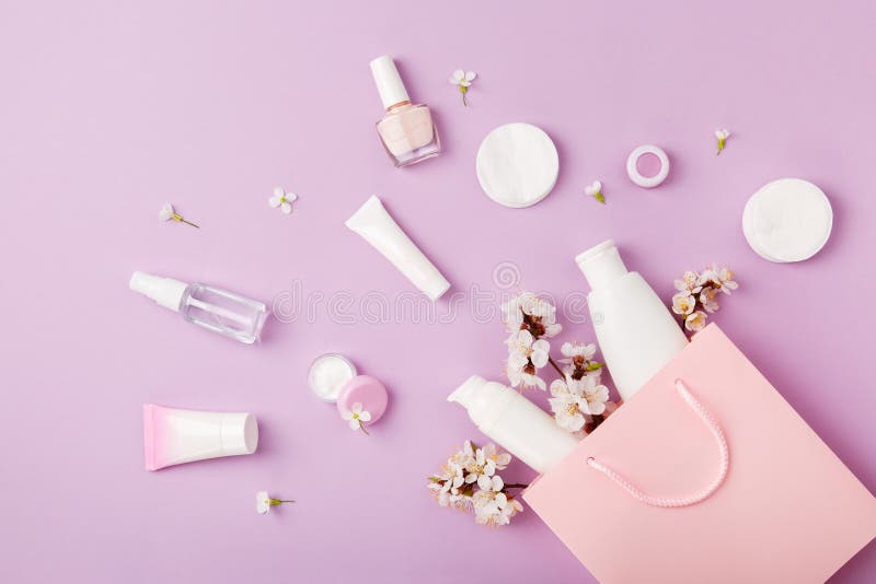 Set of woman`s cosmetics in a bag with spring apricot bloom.