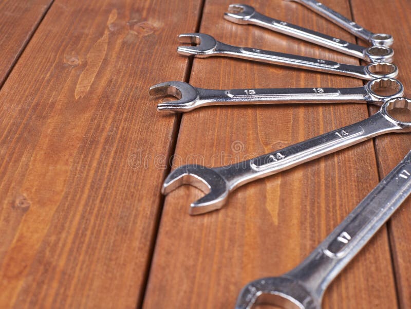Set of wrenchs chrome metal spanner instruments on wooden surface stock photography