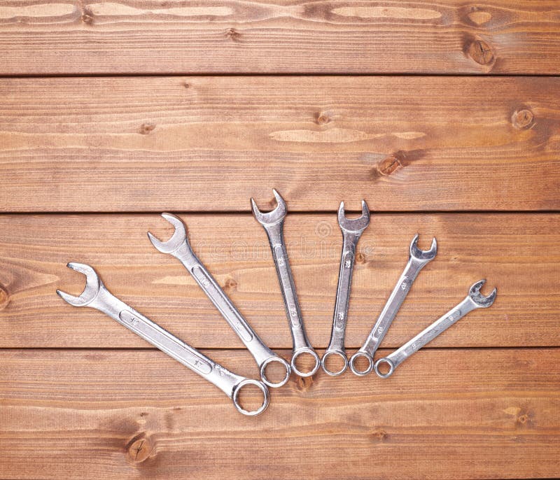 Set of wrenchs chrome metal spanner instruments on wooden surface stock photo