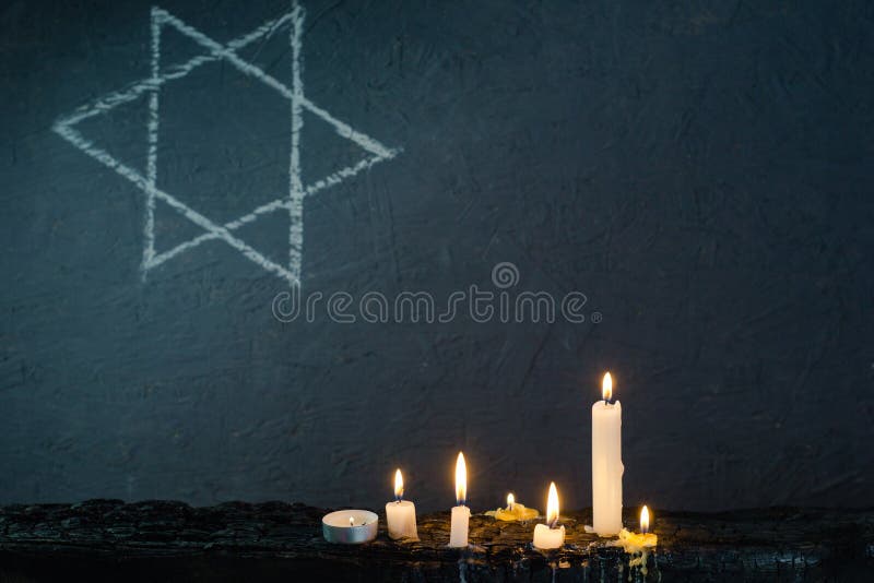 Seven burning candles on a burning table and the Star of David against. Seven burning candles on a burning table and the Star of David against