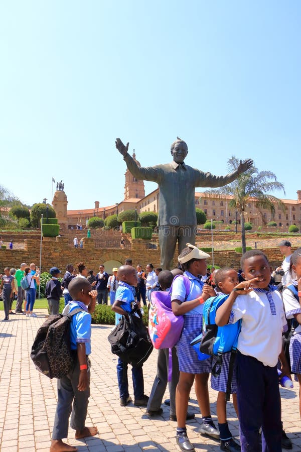29 settembre 2022 pretoria sudafrica : bambini felici nella statua di nelson mandela sulla sua piazza davanti agli edifici dell'un immagini stock libere da diritti