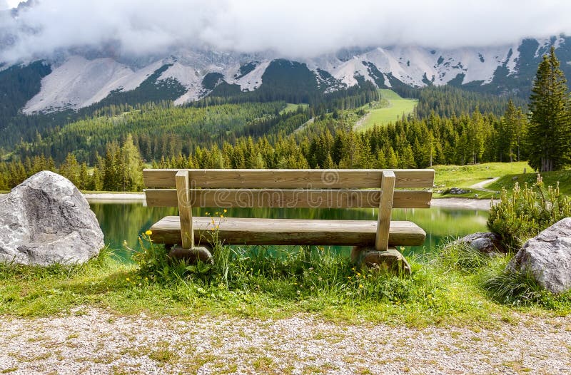 Setzen Sie nahe Almsee See in den Alpenbergen - Tirol, Österreich auf die Bank stockbild Setzen Sie nahe Almsee See in den Alpenbergen - Tirol, Österreich auf die Bank stockbild