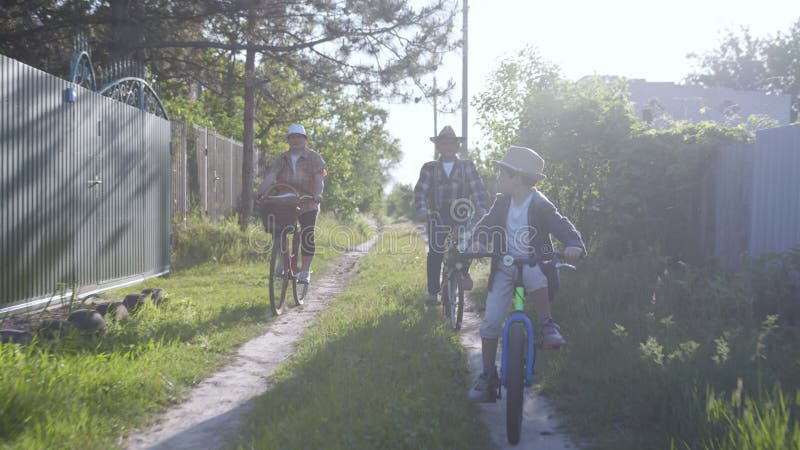 Seu netinho feliz estilo de vida e seus avós felizes se divertem e desfrutam de uma carona em comum em bicicletas e montam em uma