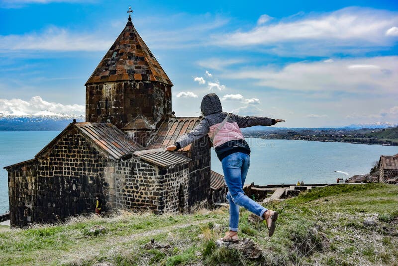 塞瓦纳万克修道院sevan monastery附近的女孩是一个位于湖滨的修道院综合建筑 免版税库存图片