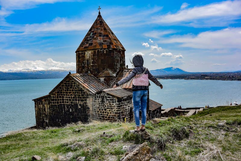 塞瓦纳万克修道院sevan monastery附近的女孩是一个位于湖滨的修道院综合建筑 库存照片