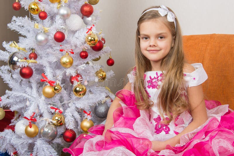 Seven-year Girl Sitting on a Sofa in Beautiful Dress the Christmas Tree ...