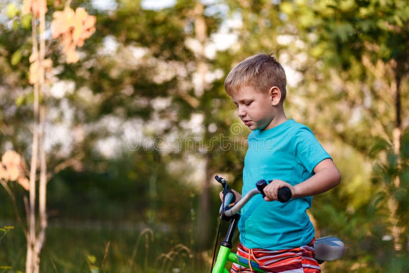 Seven-year-old boy riding a bike on a blurred natural background in the summer