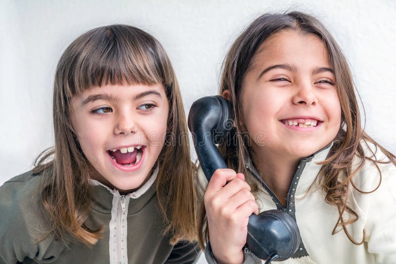 Seven year old girl talking on the old vintage phone and her sis