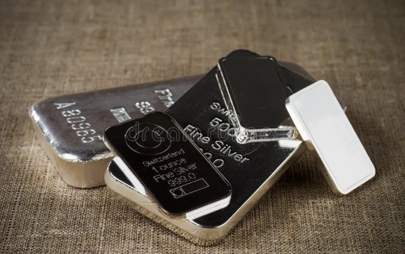 Several different silver ingots against the background of a texture of coarse cloth royalty free stock photos Several different silver ingots against the background of a texture of coarse cloth royalty free stock photos