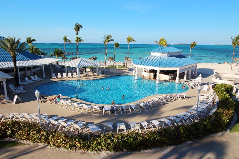 Several families enjoying their holidays time in the swimming pool of a luxury hotel resort placed close to a caribbean beach in Nassau, Bahamas.