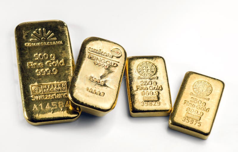 Several gold cast bars of different weights and different manufacturers lie on a white surface royalty free stock photo Several gold cast bars of different weights and different manufacturers lie on a white surface royalty free stock photo