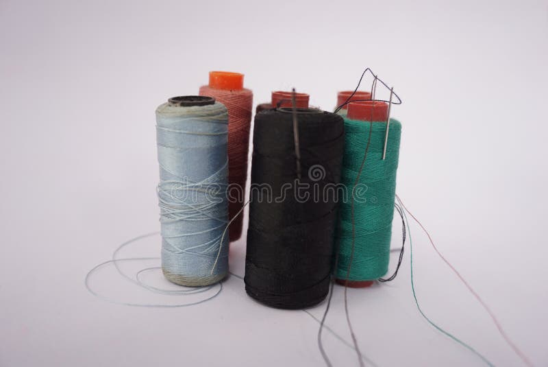 Several Piles of Sewing Thread Spools of Various Colors Isolated on a