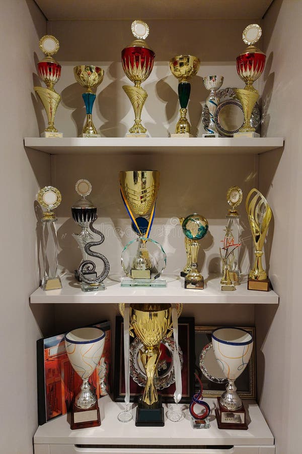 On Several Shelves There are Rows of Sports Cups for Prizes at