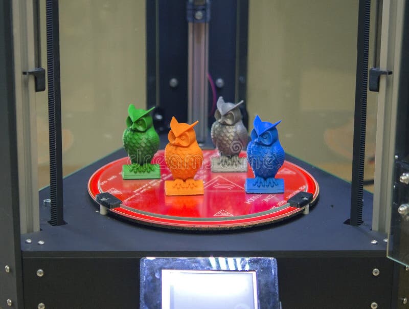 Several small objects owls stand on the working surface of the 3d printer royalty free stock photo
