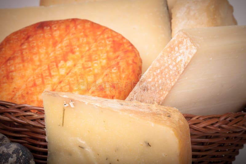 Several varieties of cheese in a wicker basket