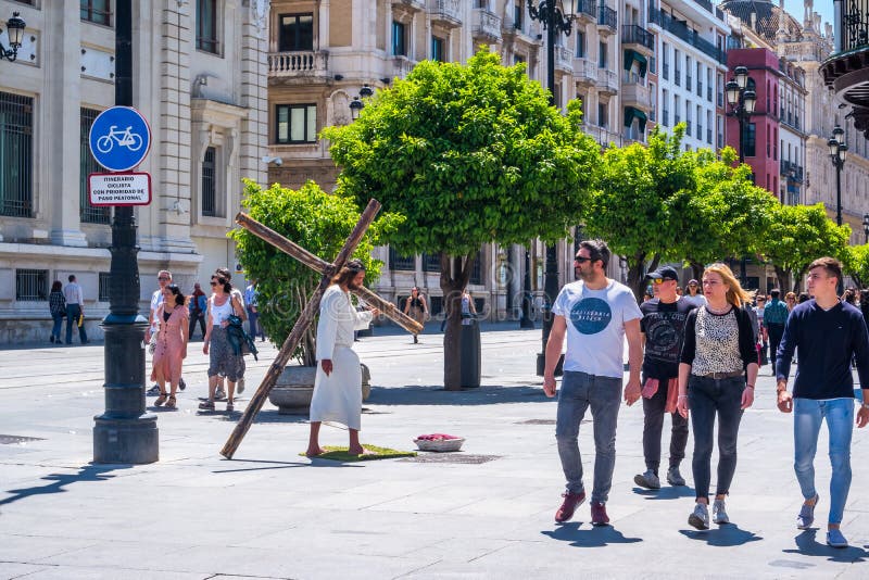 Seville, Spain May 8th 2019 street actor play Jesus Christ carrying large wooden cross stock photo Seville, Spain May 8th 2019 street actor play Jesus Christ carrying large wooden cross stock photo