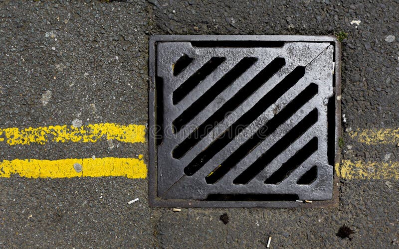 Sewer cover with double yellow lines stock photography
