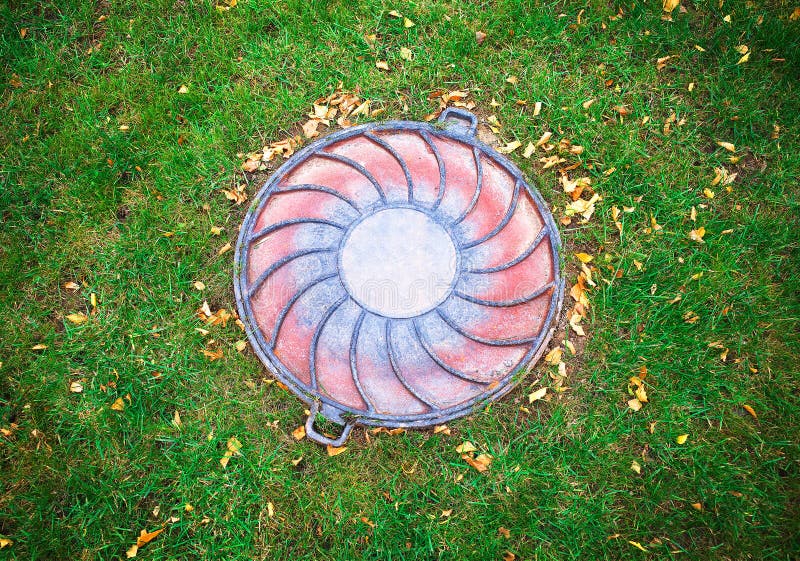 Sewer Hatch at the Center of the Lawn Garden Background Stock Image