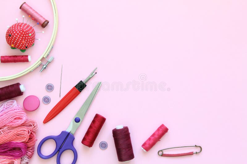 Sewing accessories on a pink background with needles, spool of thread, scissors and a tape measure stock photos Sewing accessories on a pink background with needles, spool of thread, scissors and a tape measure stock photos