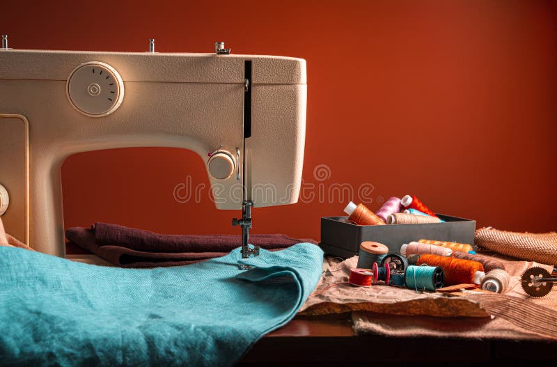 Sewing machine and sewing accessories on a brown background royalty free stock image
