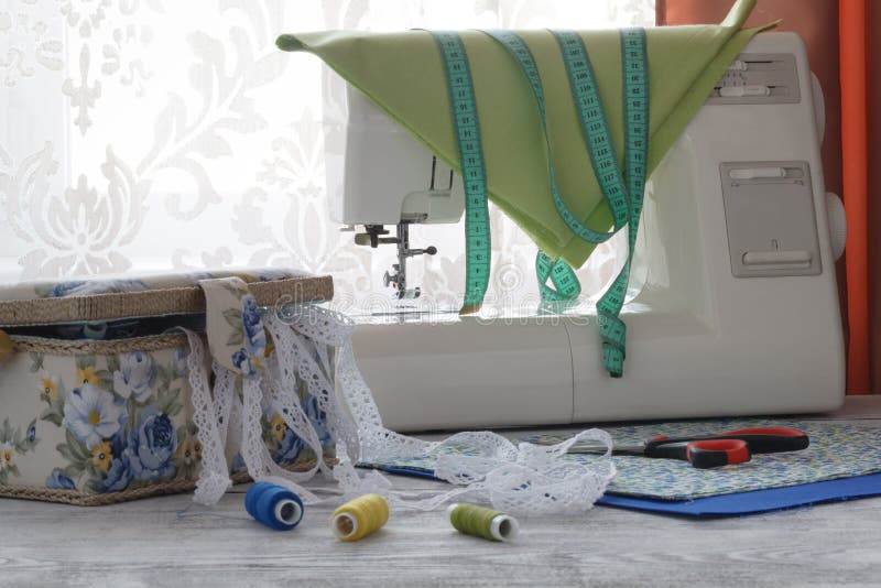 Sewing machine and fabric on white wooden table