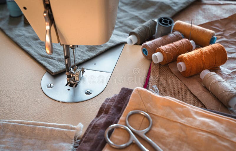 Sewing machine, thread, scissors and fabric close-up. stock photography