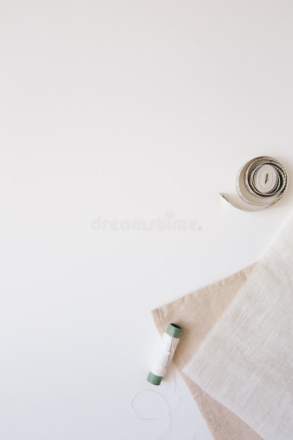 Sewing and Needlework Concept. Natural Fabrics, Cotton and a Spool of Thread on a White