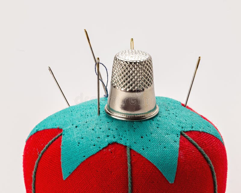 Sewing pincushion that is red and green with a thimble on top stock image Sewing pincushion that is red and green with a thimble on top stock image