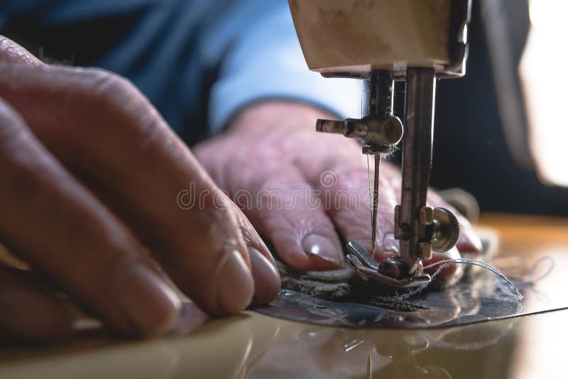 Sewing process of the leather belt. old Man`s hands behind sewing. Leather workshop. textile vintage sewing industrial stock images Sewing process of the leather belt. old Man`s hands behind sewing. Leather workshop. textile vintage sewing industrial stock images
