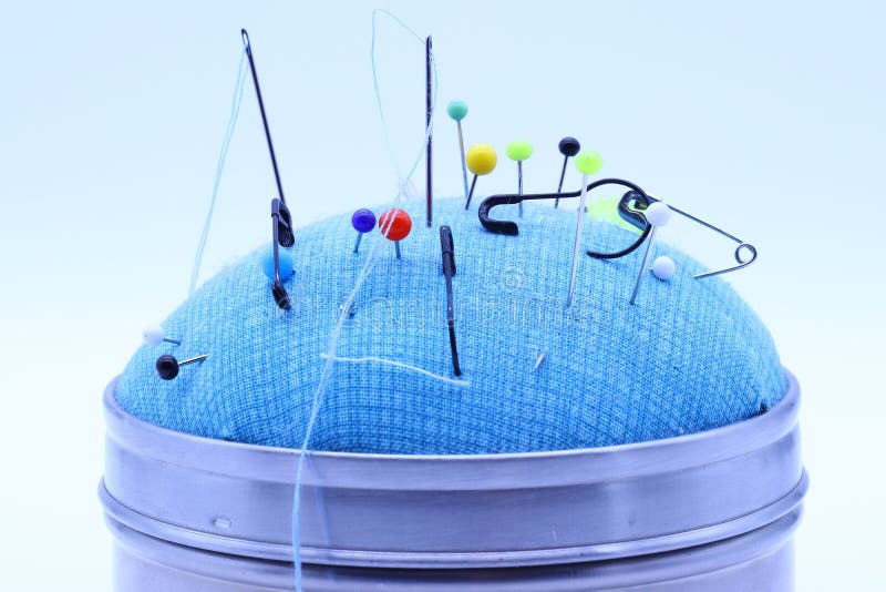 Sewing and Safety Pins Stuck on a Blue Pillow Stock Image Image of