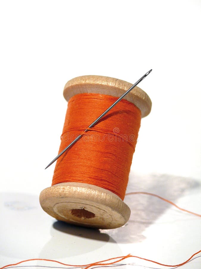 Sewing spool with a needle. A sewing needle.