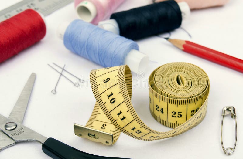 Sewing Spools, Scissors and Tape Measure on White Cloth Stock Image