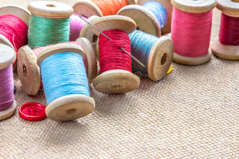 Sewing tools many different colorful thread, needle, buttons on wooden background. royalty free stock photography