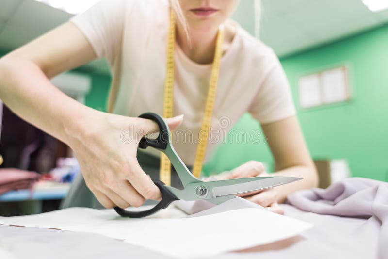Sewing Seamstress at Work. Marking and Cutting Fabric. Stock