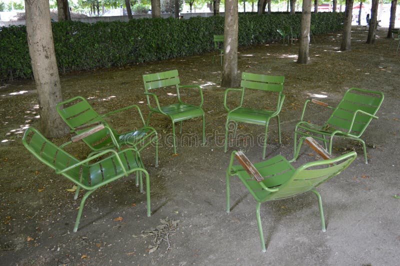 Sex gröna ordförande i cirkel i parken royaltyfri bild Sex gröna ordförande i cirkel i parken royaltyfri bild