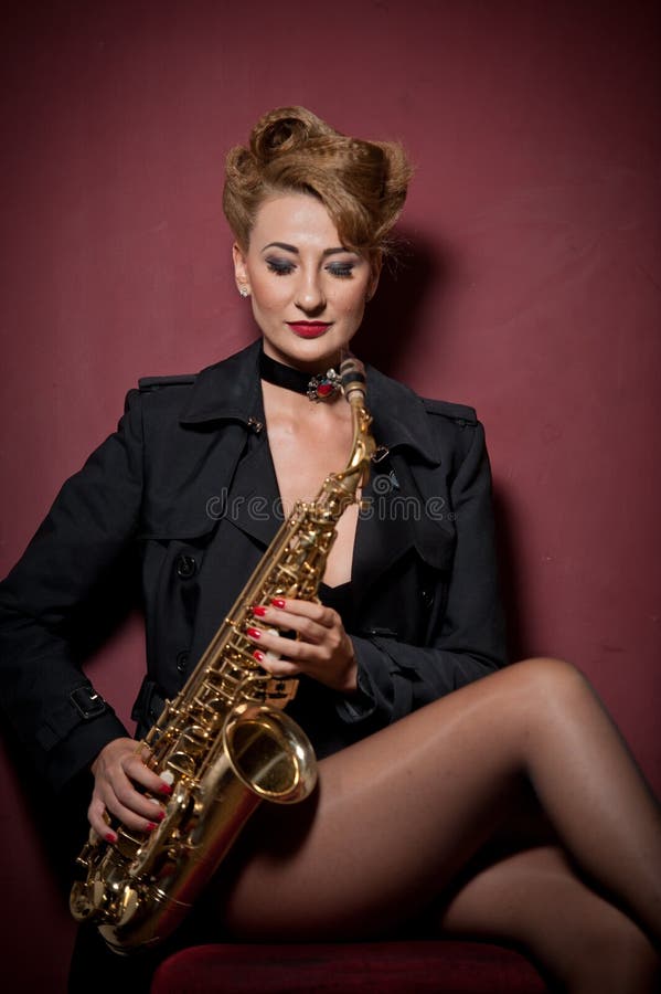 Sexig attraktiv kvinna med saxofonen som poserar på röd bakgrund Ung sinnlig blond spela saxofon Musikinstrument jazz royaltyfri foto Sexig attraktiv kvinna med saxofonen som poserar på röd bakgrund Ung sinnlig blond spela saxofon Musikinstrument jazz royaltyfri foto