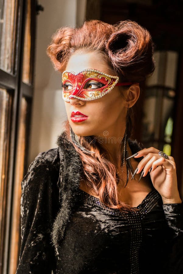 Sexig Caucasian modell med den röda maskeringen för karneval som ser till och med arkivfoton Sexig Caucasian modell med den röda maskeringen för karneval som ser till och med arkivfoton