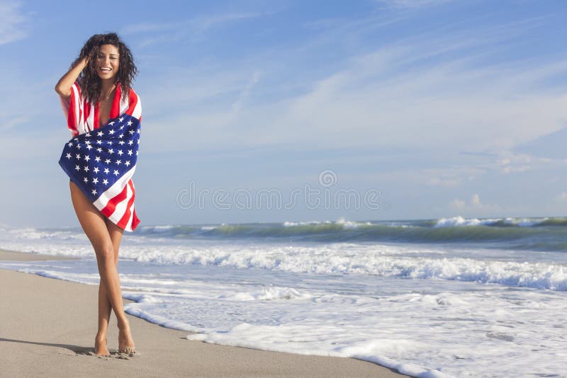 Sexig ung kvinnaflicka i amerikanska flaggan på strand arkivfoto