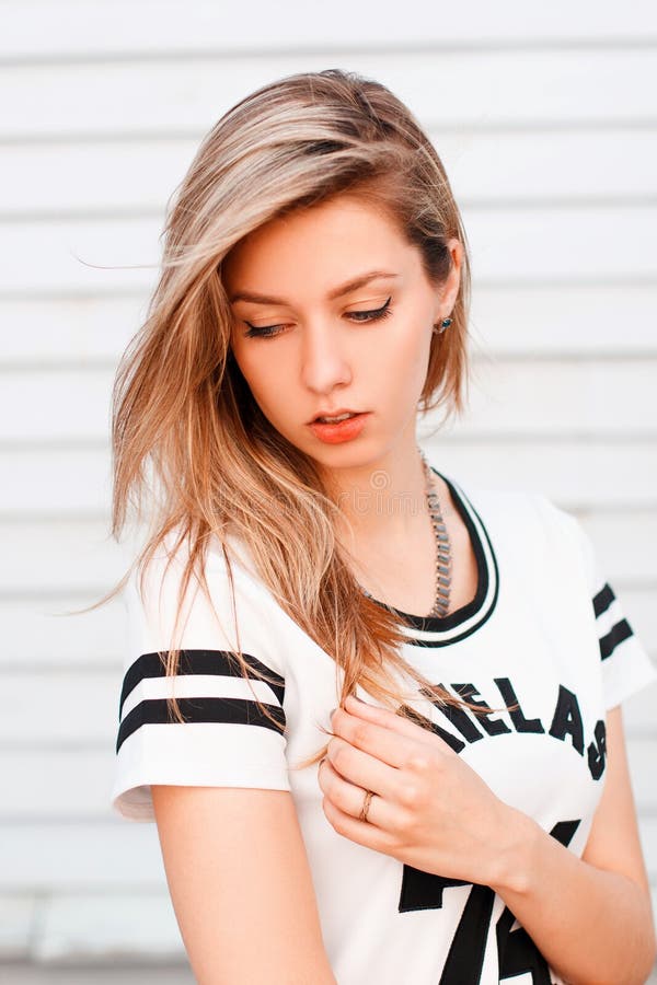 https://thumbs.dreamstime.com/b/sexy-american-girl-blonde-hair-fashionable-white-t-shirt-black-pattern-posing-posing-near-white-wooden-197225782.jpg