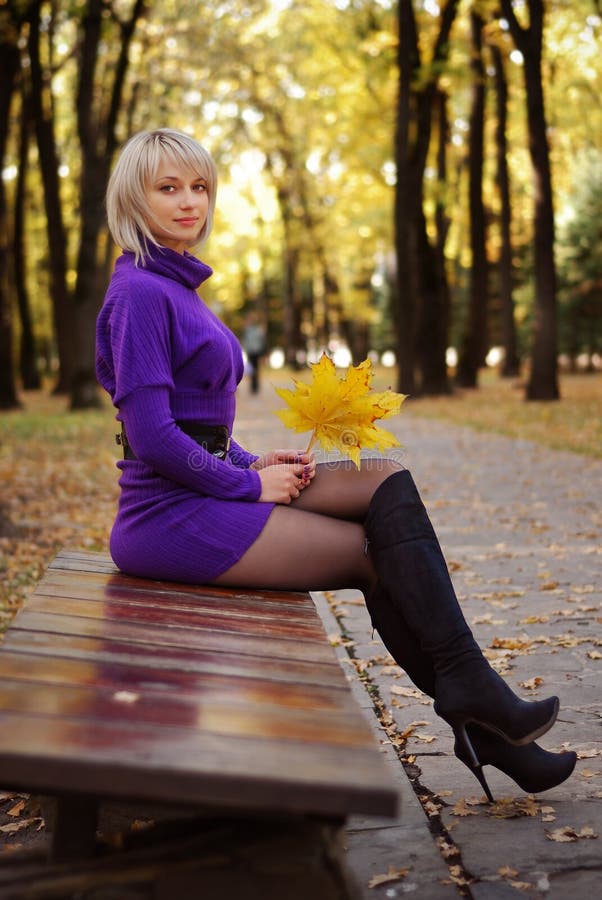 blond girl in short dress and autumn scenery