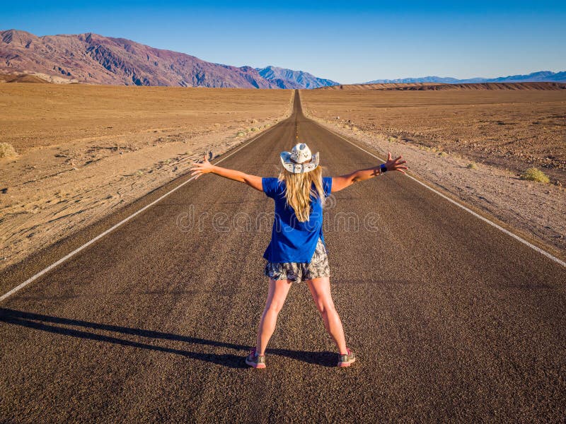 Sexy curvy woman on the lane of endless straight Badwater Road running through the barren scenery of famous Death Valley, California. It is one of the hottest places in the world. Sexy curvy woman on the lane of endless straight Badwater Road running through the barren scenery of famous Death Valley, California. It is one of the hottest places in the world.