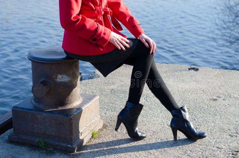Sexy elegante moderne Dame, die neben Fluss sitzt lizenzfreie stockbilder