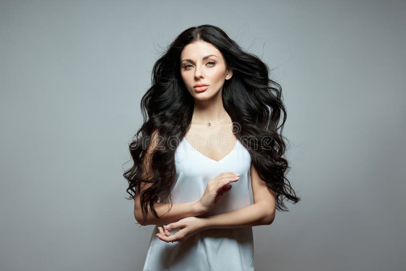 Sexy fashion woman with long hair, curly strong hair of a brunette girl. Natural cosmetics for hair care, strong roots