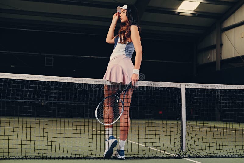 female tennis player posing on a tennis court.