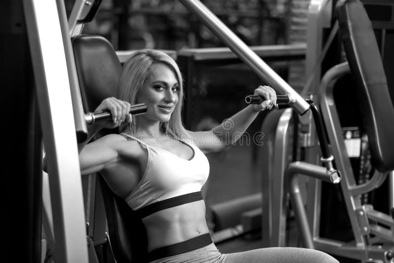 Fitness Blonde Woman Is Sitting On Training Apparatus And Posing Bw Stock Image Image Of