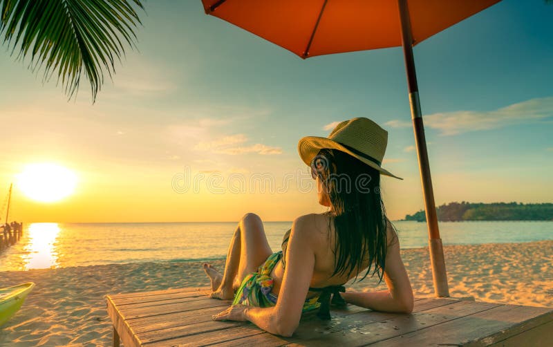 Sexy, genießen Sie und entspannen Sie sich den Frauenabnutzungsbikini, der auf sunbed am Sandstrand am Paradiestropeninselstrand