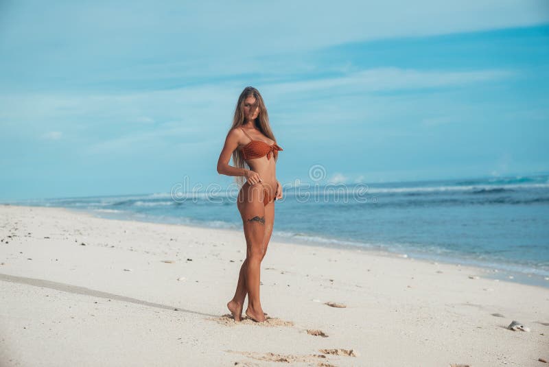 Sexy großes junges Mädchen mit Sport stellen Stände auf dem Strand auf dem Strand allein, der Wind wirft ihr Haar auf ihrem Gesic lizenzfreies stockfoto Sexy großes junges Mädchen mit Sport stellen Stände auf dem Strand auf dem Strand allein, der Wind wirft ihr Haar auf ihrem Gesic lizenzfreies stockfoto