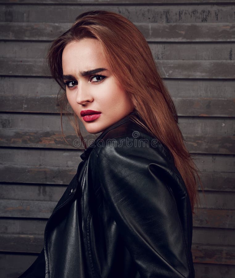 long hair woman with red lipstick in black jacket on street